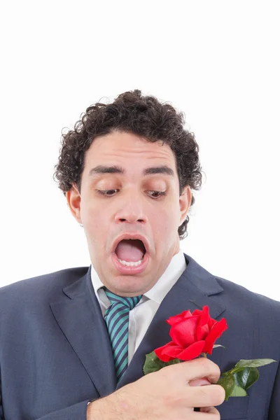 Man in suit with weird face expression holding with his hand ros — Stock Photo, Image