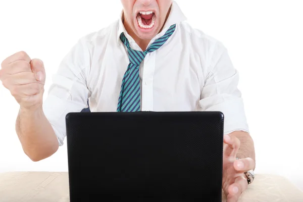 Anonymous businessman smashing his laptop on table with fist — Stock Photo, Image