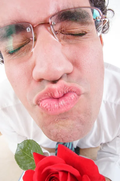 Guy trying to be romantic giving a kiss holding rose — Stock Photo, Image