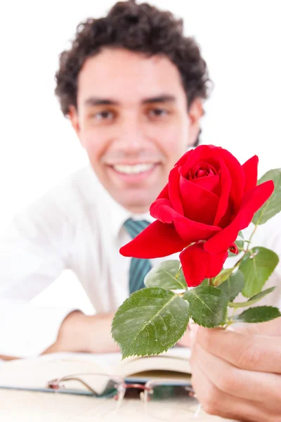 Uomo romantico che tiene in mano rosa con libro e bicchieri sul tavolo — Foto Stock