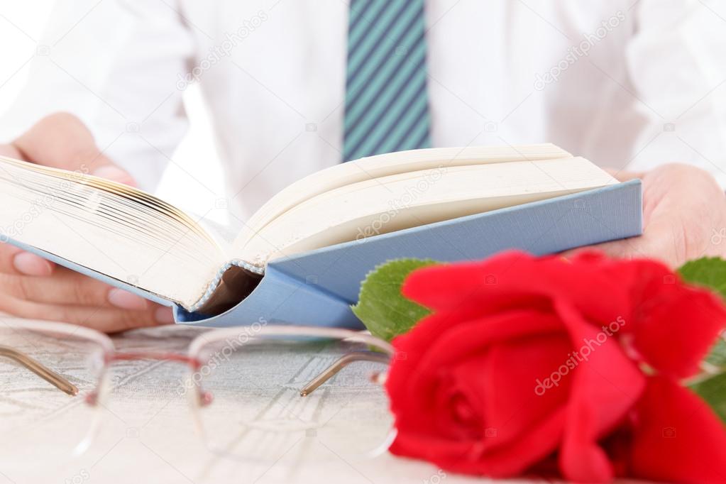 Composition with book, glasses and red rose