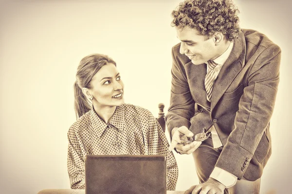 Boss and smiling secretary working together on laptop — Stock Photo, Image