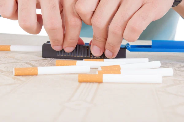 Mãos fazendo charutos usando rolos e papel pegajoso com tabaco — Fotografia de Stock