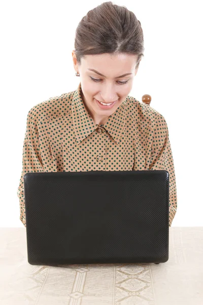 女人穿着衬衫坐在和使用在线聊天的便携式计算机 — 图库照片