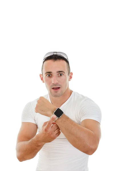 Confuso hombre guapo en camiseta blanca apuntando un dedo a la cloc — Foto de Stock