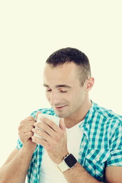 Χαρούμενος νεαρός απολαμβάνει ζεστό ρόφημα, πίνοντας τον καφέ από την κούπα — Φωτογραφία Αρχείου