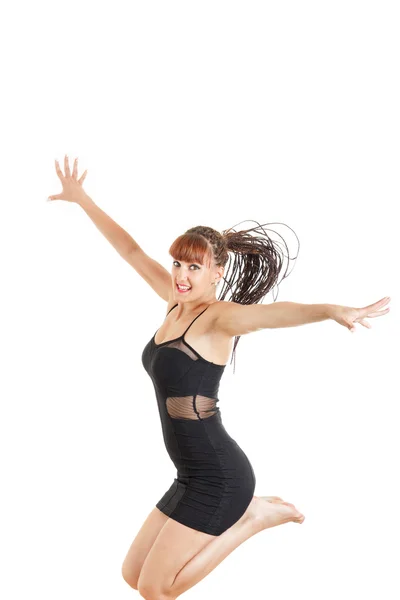 Smiling young woman jumping in the air with open arms — Stock Photo, Image