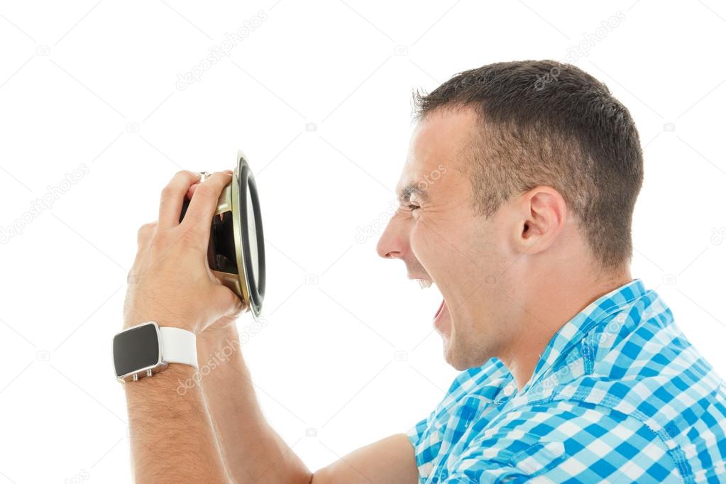Young man holding object loudspeaker listening to loud music yel