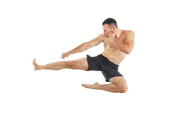 Lutador de boxe atlético executando um pontapé lateral voador — Fotografia de Stock