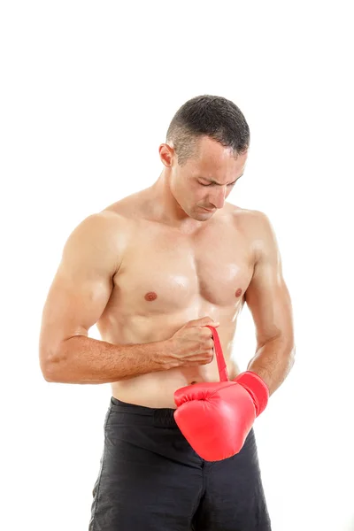 Hombre en forma poniendo sus guantes de boxeo, preparándose para el entrenamiento sobre w — Foto de Stock