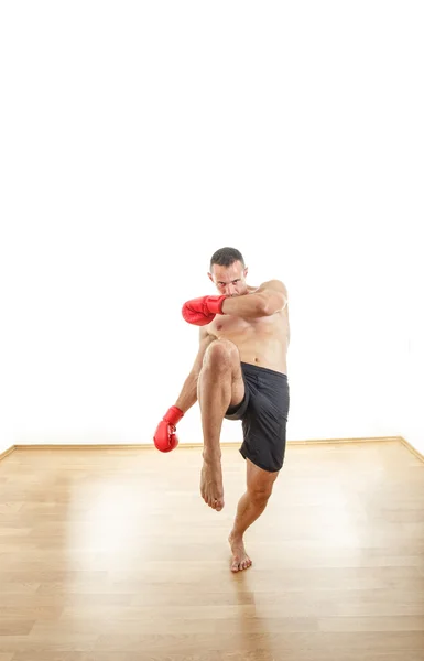 Uomo con i guanti da boxe pronto a calciare gli avversari — Foto Stock