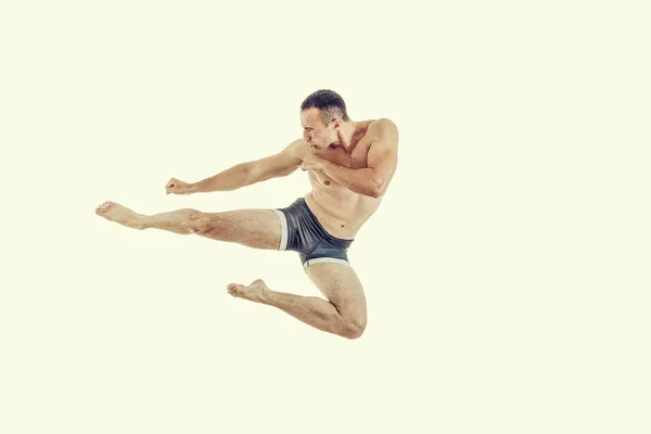 One caucasian man exercising boxing jumping in the air kicking — Stock Photo, Image