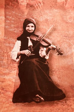 Sırp ulusal kostüm yaşlı bir kadın oturur ve vio çalış
