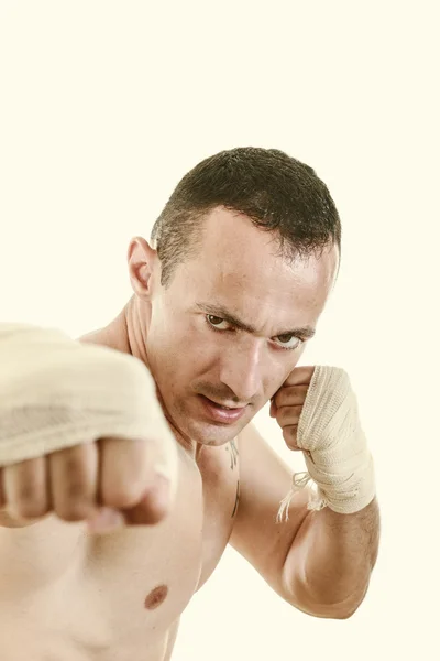 Vechter met een pleister op handen in vechter positie en punch wit — Stockfoto