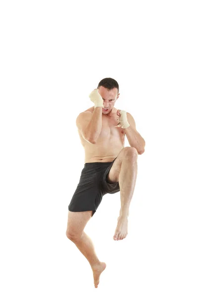 Athletic fighter with bandages on hands jumping — Stock Photo, Image