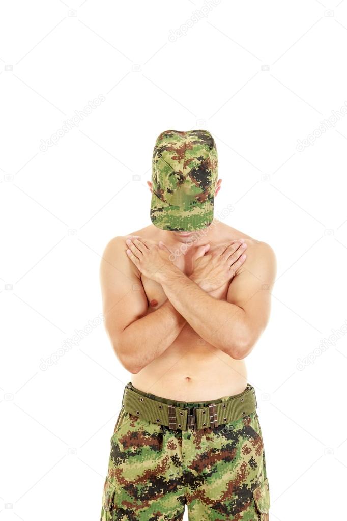 Military combatant officer praying with arms crossed and head bo