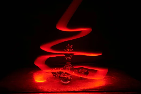 Spirales rouges de lumière autour du jouet en verre — Photo