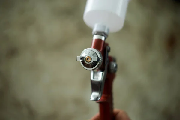 Small red spray gun in human hand — Stock Photo, Image