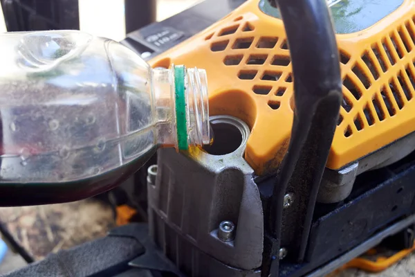 Pouring oil into the chainsaw chain lubrication tank