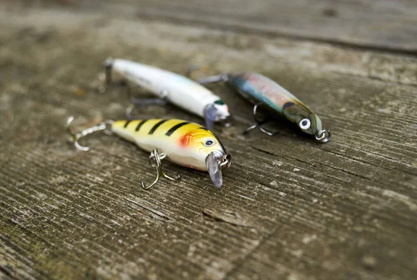 Three wobblers for predatory fish on the wood