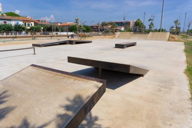 BARCELONA, İspanya - 19 Eylül 2021: Premia de Mar limanındaki bir kaykay meydanında beton ve demir rampalar