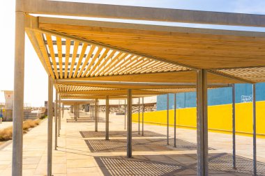BARCELONA, İspanya - 2 Ekim 2021: Barselona 'daki Forum limanının önündeki gölgeyi sağlamak için ahşap çatılı kulübelerin yakın çekimi