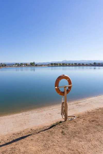 Σωσίβιο Επιπλέουν Ένα Στύλο Μπροστά Από Μια Λίμνη Μια Ηλιόλουστη — Φωτογραφία Αρχείου