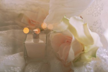 Parfüm şişesi ve açık renkli güller