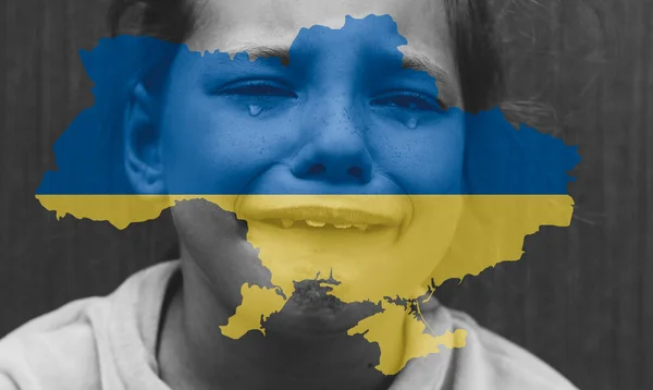 child with the flag of Ukraine is crying. Sadness longing hope. Tear macro. Children\'s tears from the war. Evacuation of civilians. Freedom to Ukraine