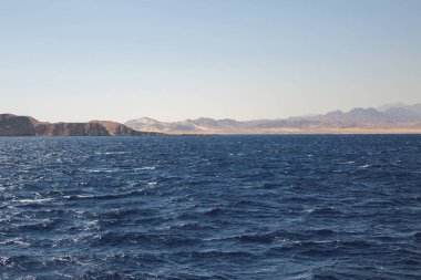 Huzurlu deniz manzarası. Sakin denizin üzerindeki güzel mavi gökyüzü ve güneş ışığı yansıması. Deniz dalgaları.