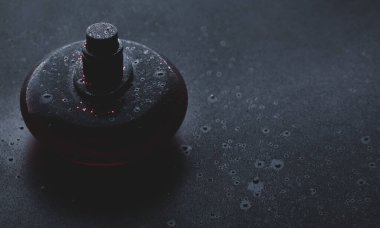 Siyah parfümlü, siyah arka planda damlalar