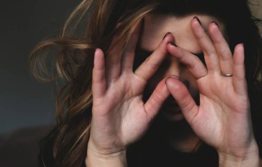 Üzgün kadın elleriyle yüzünü kapatıyor. Depresyon