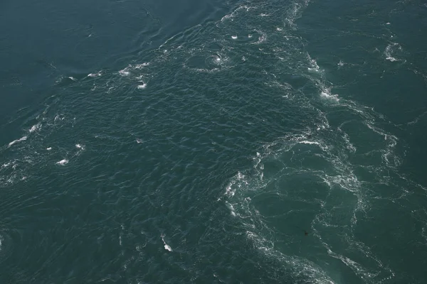 白い渦巻きを持つ深い緑の海のパッチを見下ろします — ストック写真
