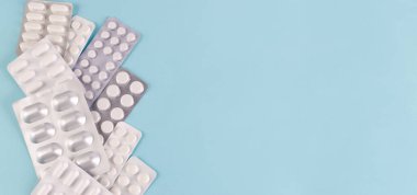 Pills in blisters on a blue background. Place for text.