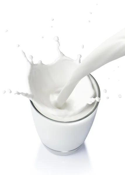 Gieten van een glas melk maken splash op een witte achtergrond — Stockfoto