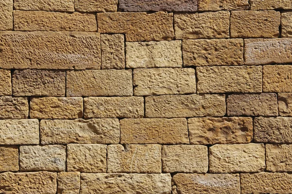 Pared de ladrillo de arena dorada para fondo o textura. Primer plano de la pared de piedra de arena amarilla — Foto de Stock