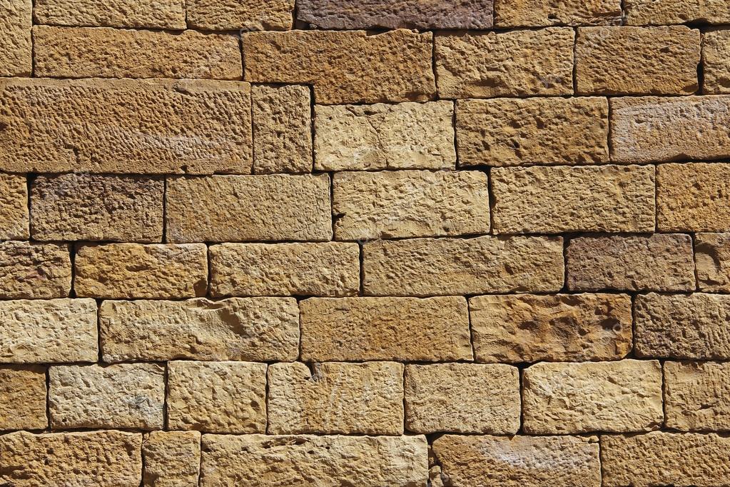 Gold sand brick wall for background or texture. Closeup of yellow sand