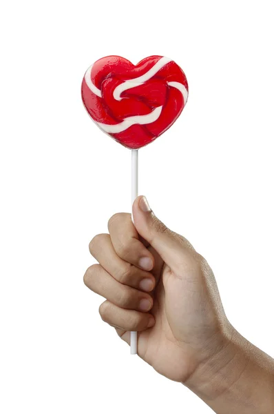 Hand hält Lutscher in Herzform, Valentinstag Süßigkeiten Lollypop isoliert auf weißem Hintergrund — Stockfoto
