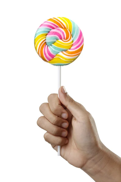 Ręka trzyma spirala kolorowy lizak cukierki na kij — Zdjęcie stockowe