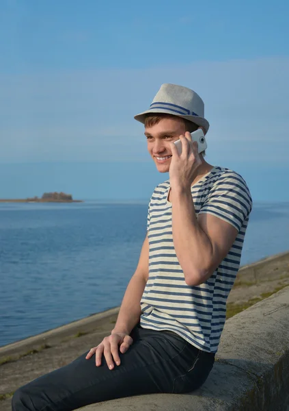 Jeune homme parlant sur un téléphone portable et souriant — Photo