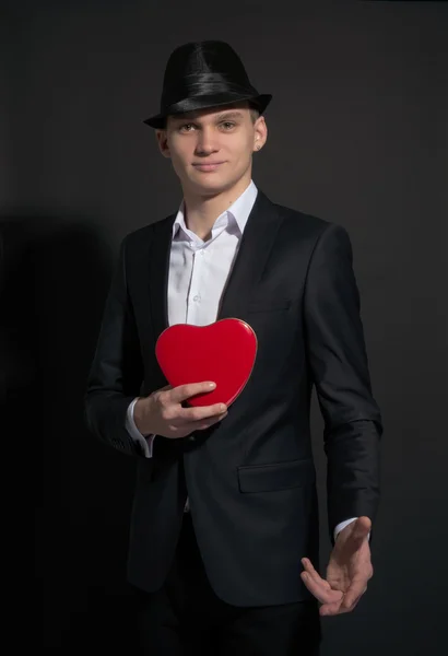 Junger Mann mit einer Schachtel wie Herzensliebe — Stockfoto