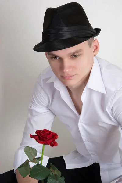A young man in a hat with a rose. — Stock Photo, Image
