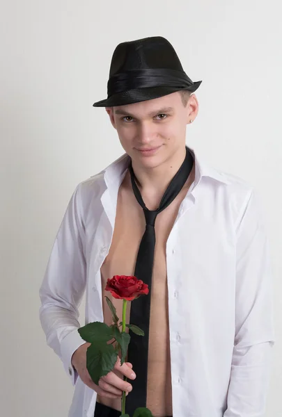 A young man in a hat and a tie with a rose. — Stock Photo, Image