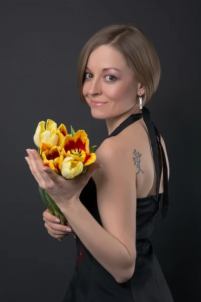 Girl in black dress with tulips — Stock Photo, Image