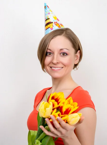 Mujer celebrando cumpleaños con tulipanes, sombrero de fiesta —  Fotos de Stock