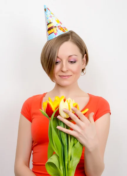 Mujer celebrando cumpleaños con tulipanes, sombrero de fiesta —  Fotos de Stock