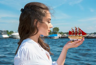 Girl holds a small ship with red sails.  Modern Assol. clipart