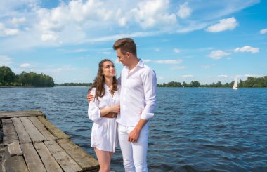 adam suya yakın ahşap bir iskele üzerinde bir kız hugs.