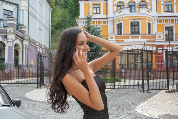 Hermosa mujer hablando en un teléfono móvil en una calle de la ciudad . —  Fotos de Stock