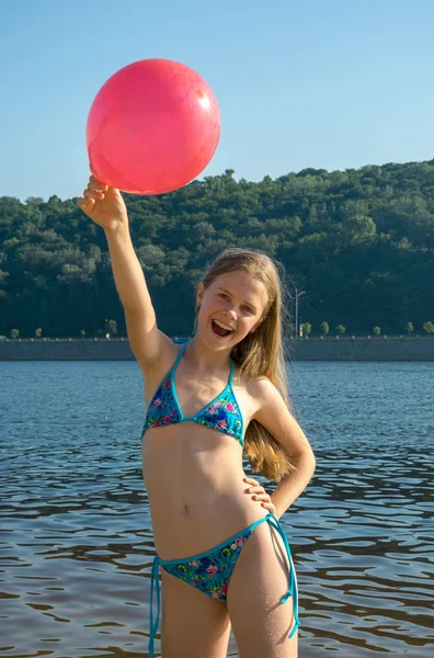 Glad tjej med röd ballong på stranden — Stockfoto
